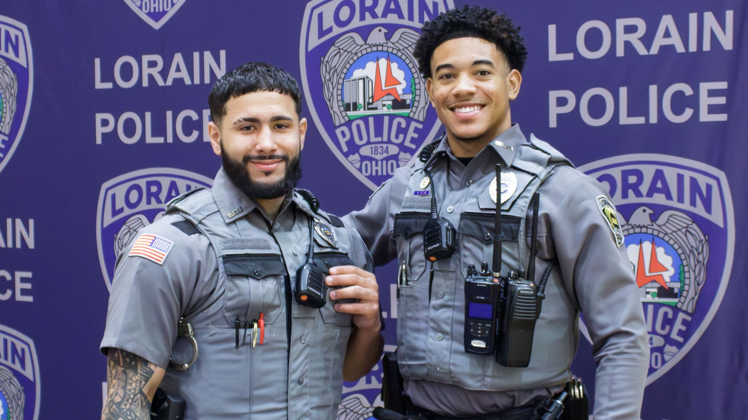 Auxiliary Police Officers standing in front of table during a job fair.