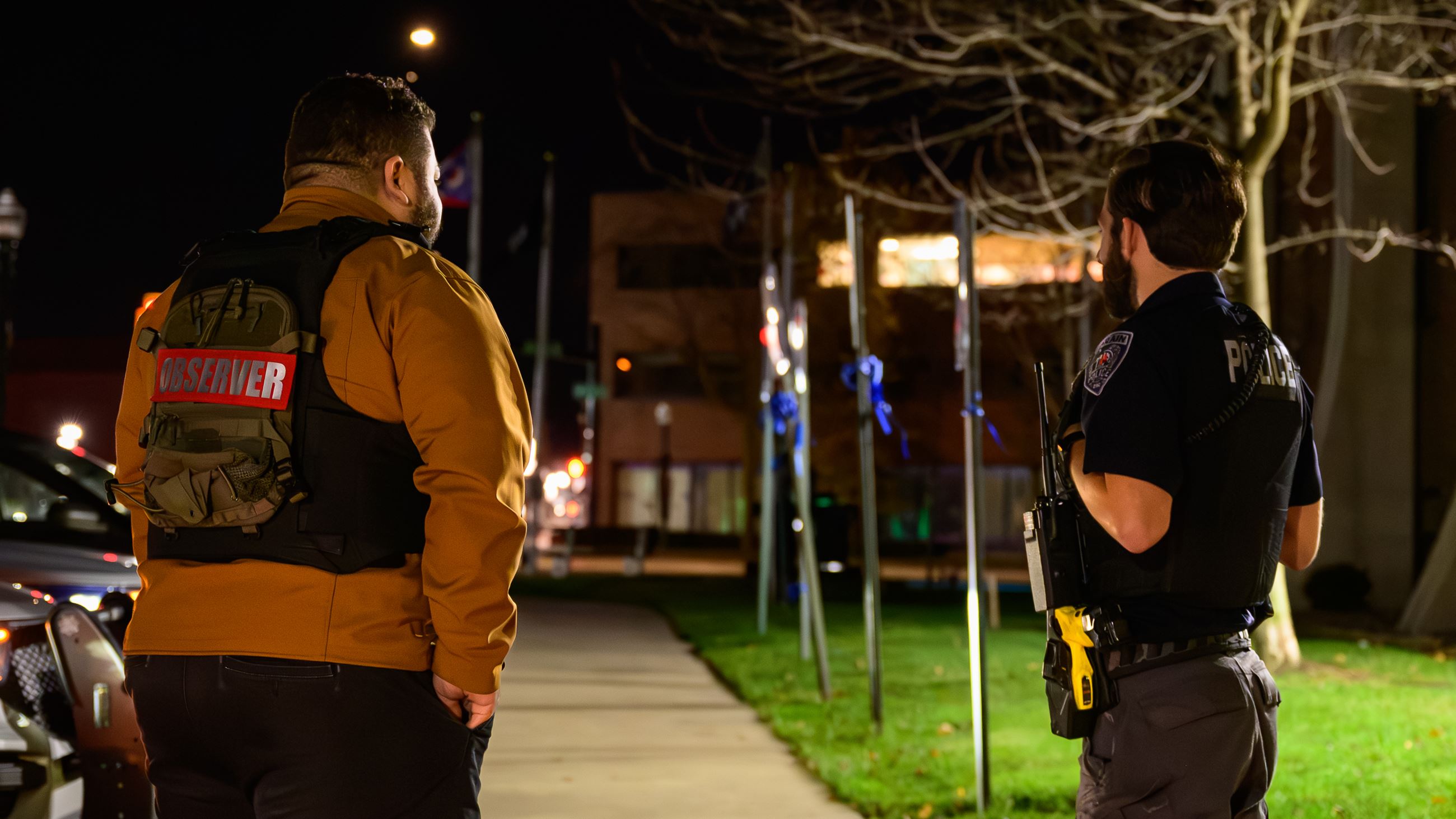 Ride along observer and Officer standing beside each other on side walk.