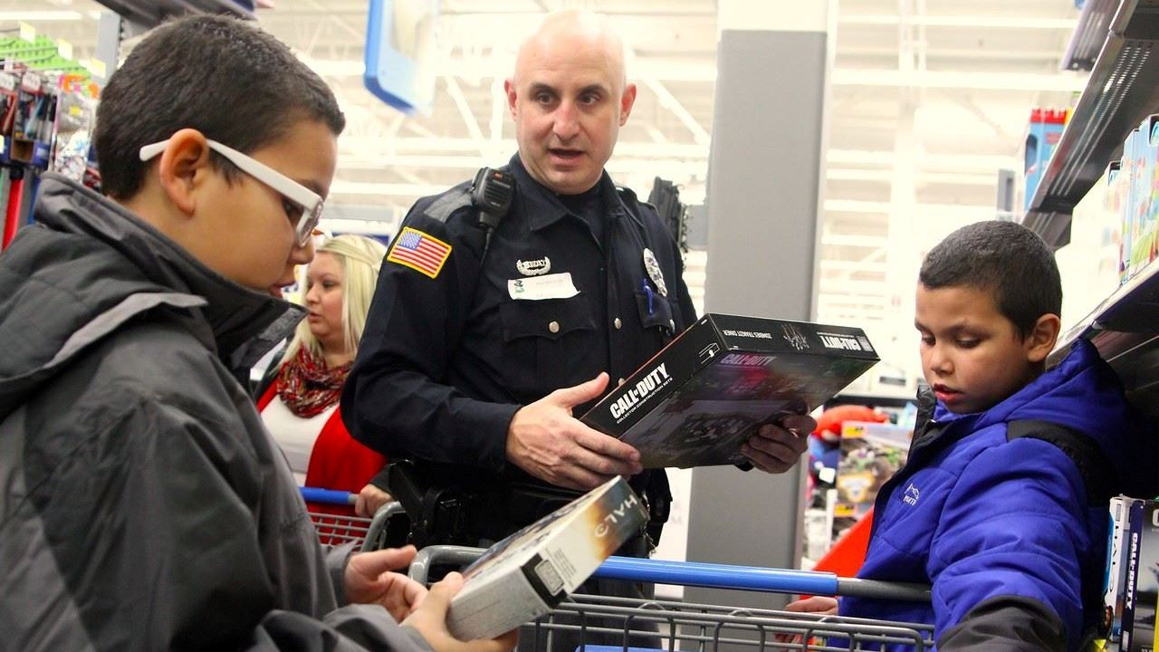 Lorain Police officer assisting children while shopping during a community holiday event